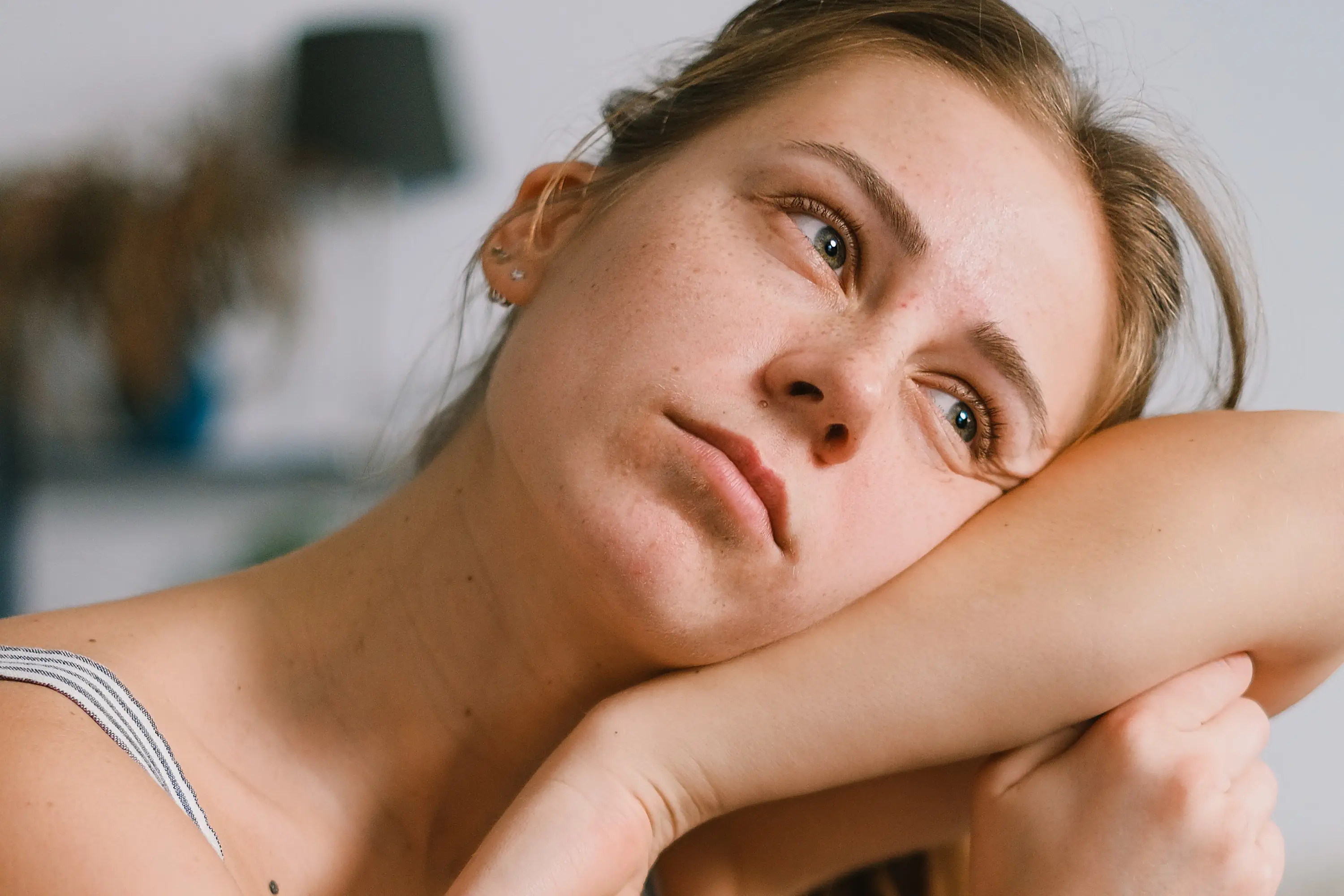 person looking into the distance with their head resting on their arm